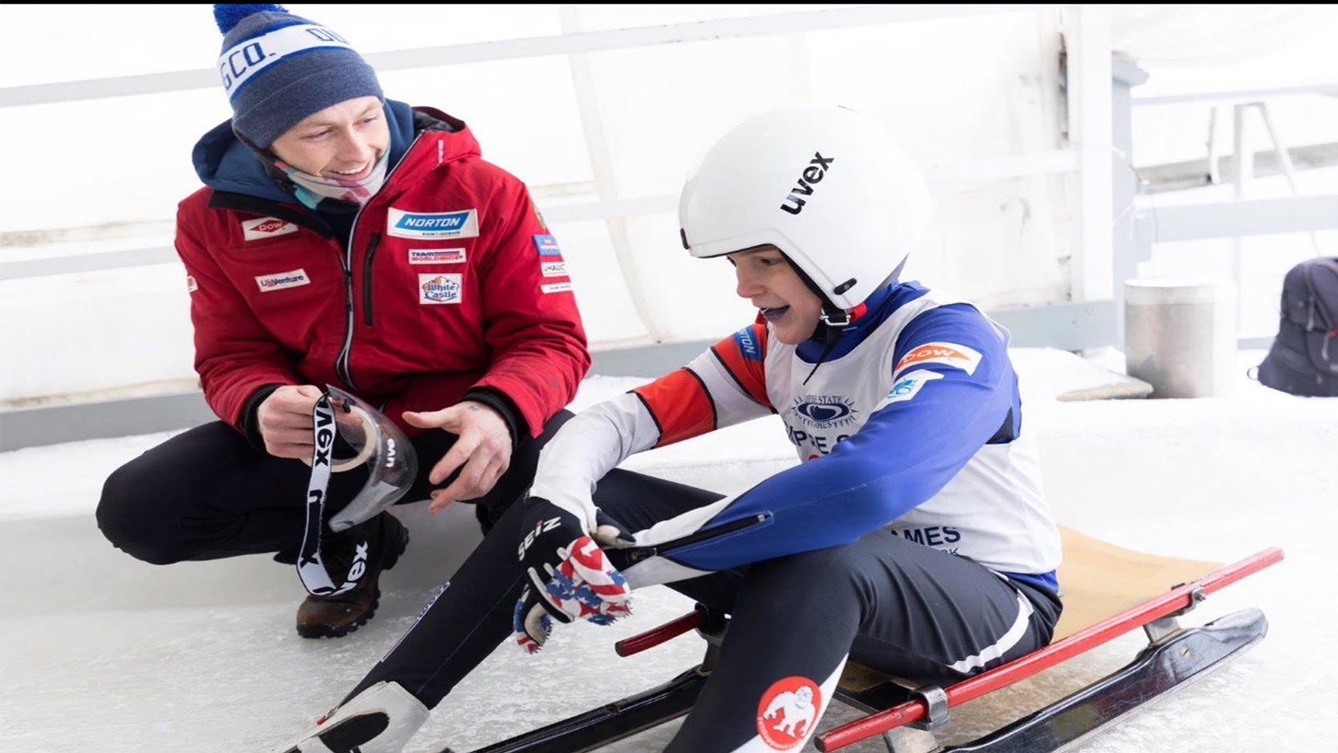 Logan Barnes working with his luge coach on sled preparation and technique