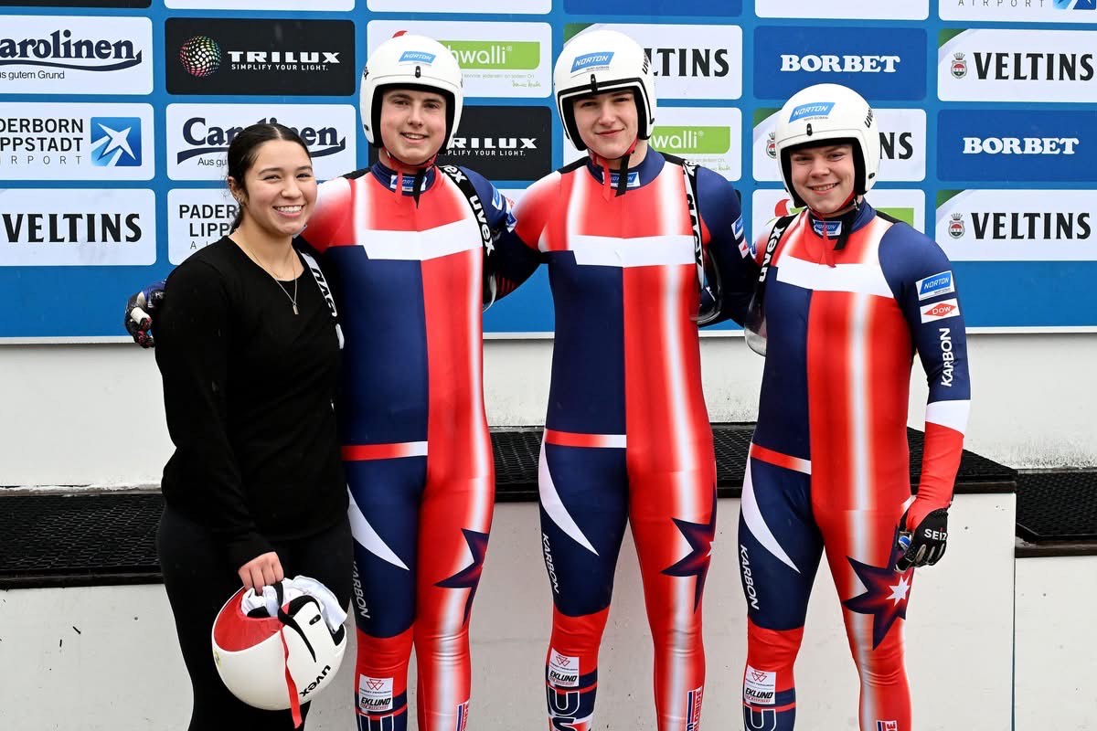 Logan and teammates in Team USA racing suits at competition